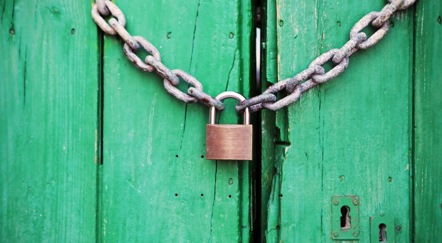 Green doors locked with a chain and a lock